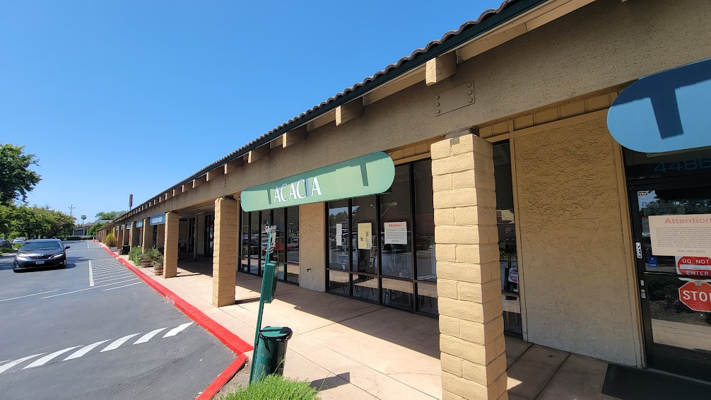 Acacia Pet Clinic storefront with visible signage, sunny day, surrounding parking area.